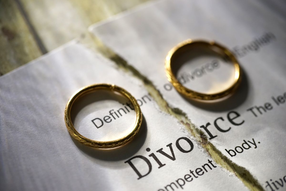 wedding rings laying on divorce papers
